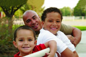 Man with children stood next to railings