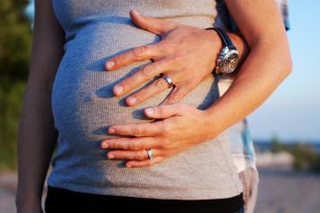 Pictire of a stethoscope held to a heavily pregnant womans stomach